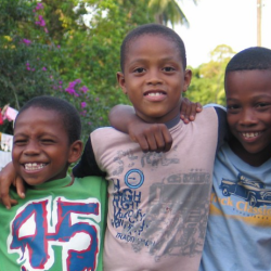 cinco niños afrocolombianos abrazados 