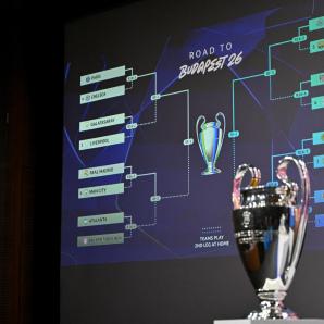 Esta fotografía muestra la Copa de la Liga de Campeones de la UEFA junto a una pantalla en la que se muestran los resultados del sorteo de los octavos de final, cuartos de final y semifinales de la Liga de Campeones de la UEFA 2025-2026 en la Casa del Fútbol Europeo en Nyon, Suiza. AFP