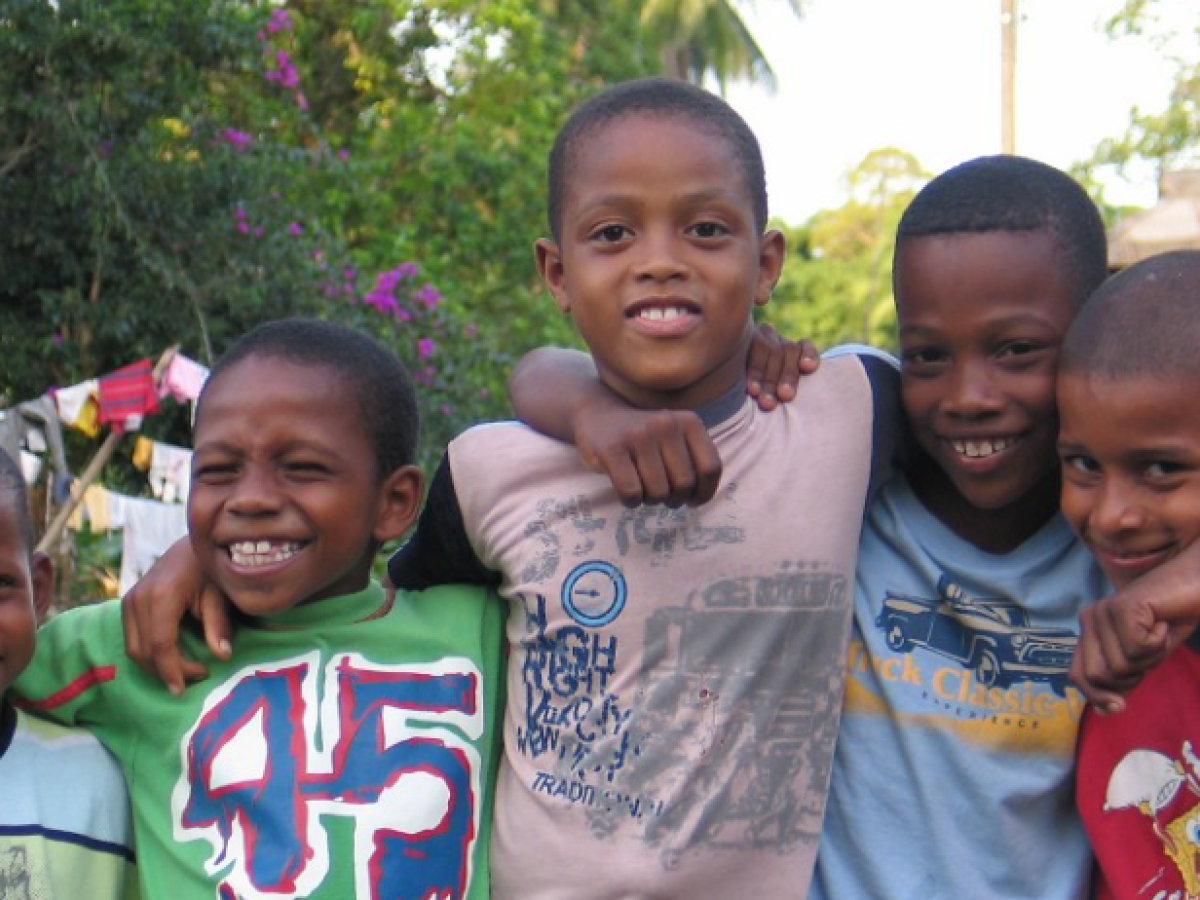 cinco niños afrocolombianos abrazados 
