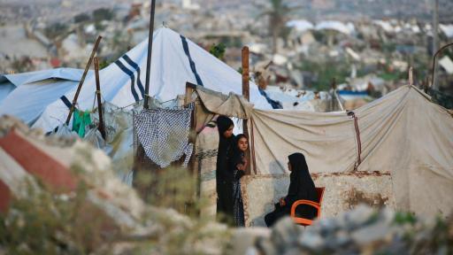 Mujeres palestinas charlan fuera de un refugio improvisado en el campo de refugiados de Nuseirat, en el centro de la Franja de Gaza.