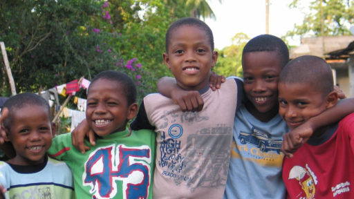 cinco niños afrocolombianos abrazados 