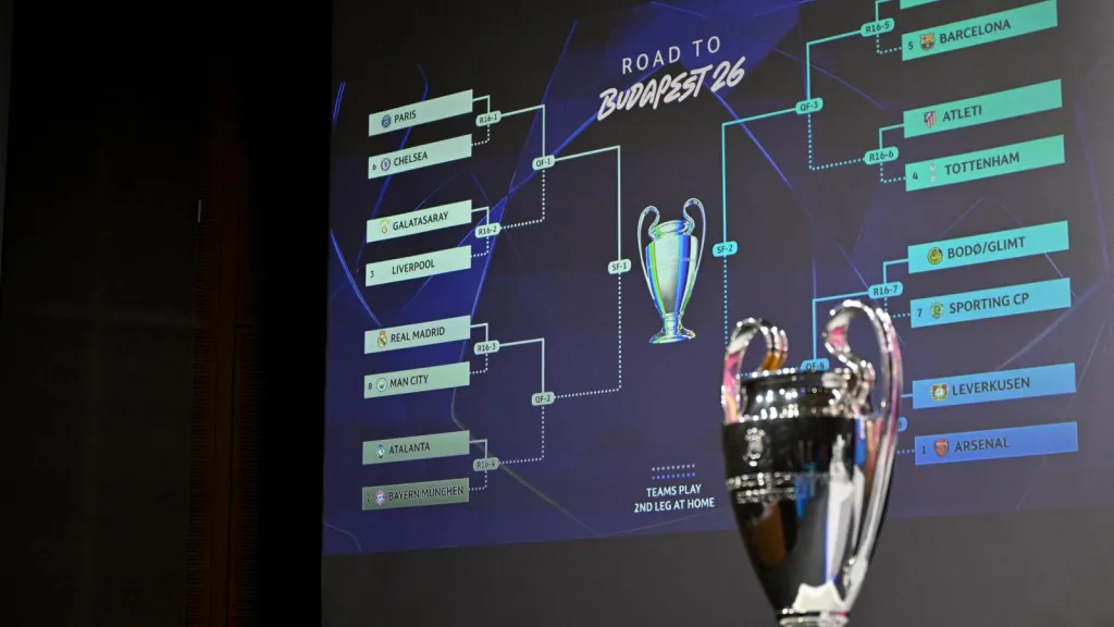 Esta fotografía muestra la Copa de la Liga de Campeones de la UEFA junto a una pantalla en la que se muestran los resultados del sorteo de los octavos de final, cuartos de final y semifinales de la Liga de Campeones de la UEFA 2025-2026 en la Casa del Fútbol Europeo en Nyon, Suiza. AFP