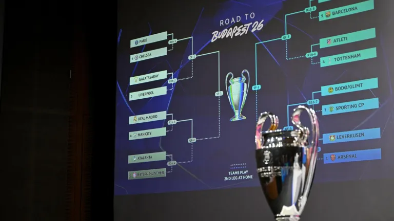Esta fotografía muestra la Copa de la Liga de Campeones de la UEFA junto a una pantalla en la que se muestran los resultados del sorteo de los octavos de final, cuartos de final y semifinales de la Liga de Campeones de la UEFA 2025-2026 en la Casa del Fútbol Europeo en Nyon, Suiza. AFP