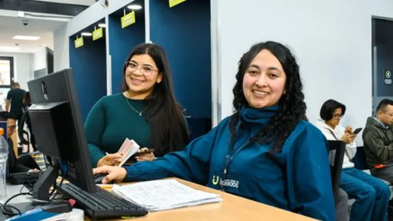 Ciudadana sonríe al ser atendida por una analista de la Ventanilla Única de Servicios - Foto: Valentina Bachiller © Consorcio Circulemos Digital, 2026